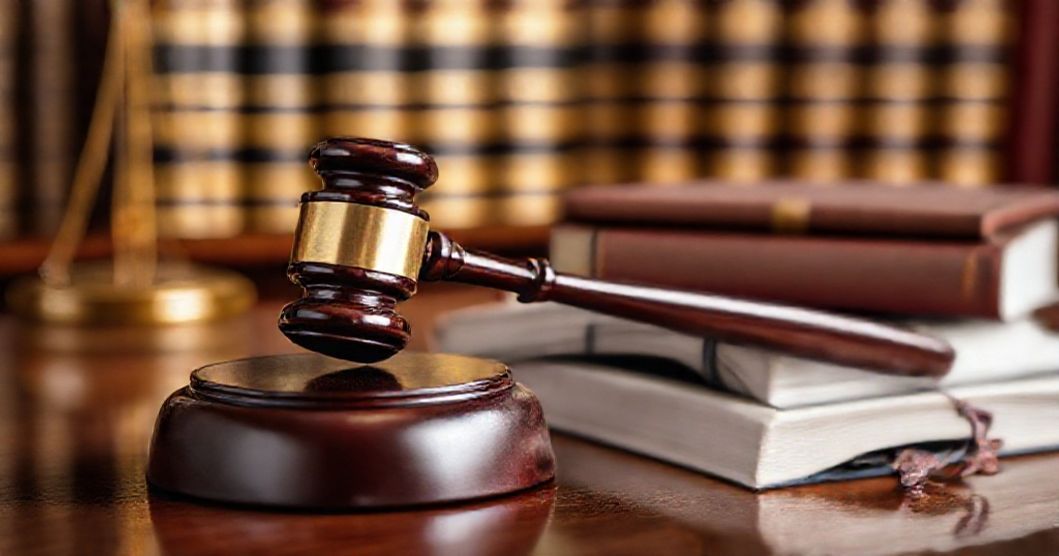 Libri di diritto e martelletto del giudice sul tavolo